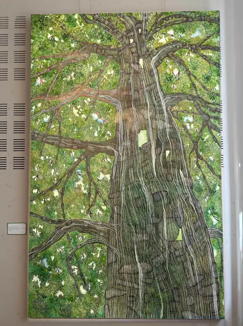 Arbre sentimental : un tronc immense dessiné en lignes grises entrelacées, sur un feuillage vert lumineux.
