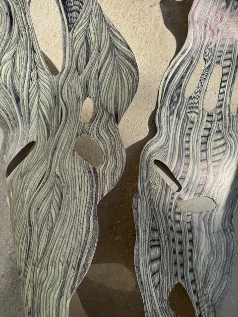 Deux bandes de papier découpées et dessinées, posées côte à côte.
