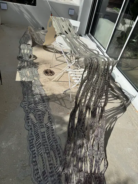 Les bandes de papier dessinées étalées sur une terrasse au soleil, avant l'accrochage.