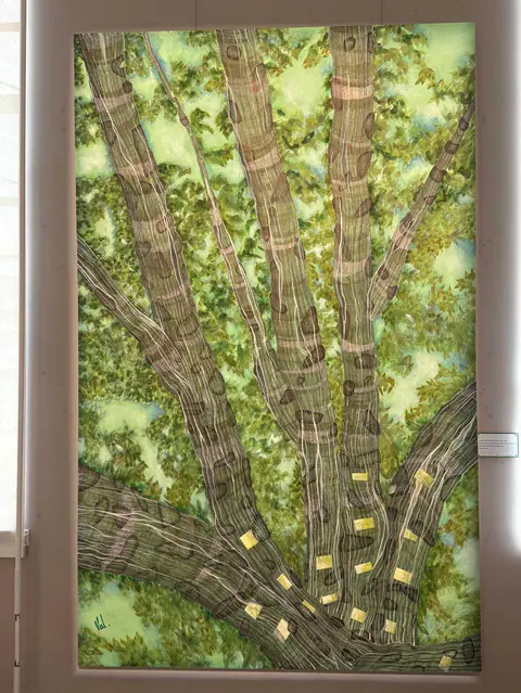 Un milliard d'années plus tard : des branches rayées de gris s'élèvent dans un feuillage vert ponctué de petites formes dorées.